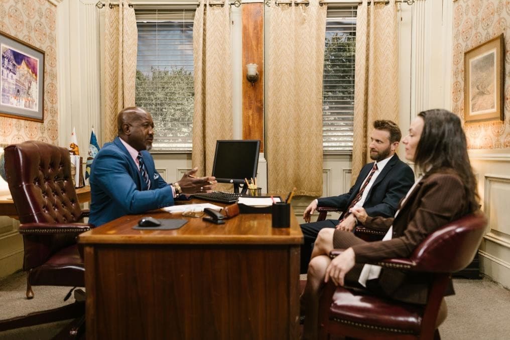 A family law attorney advising a couple across a desk during a first consultation