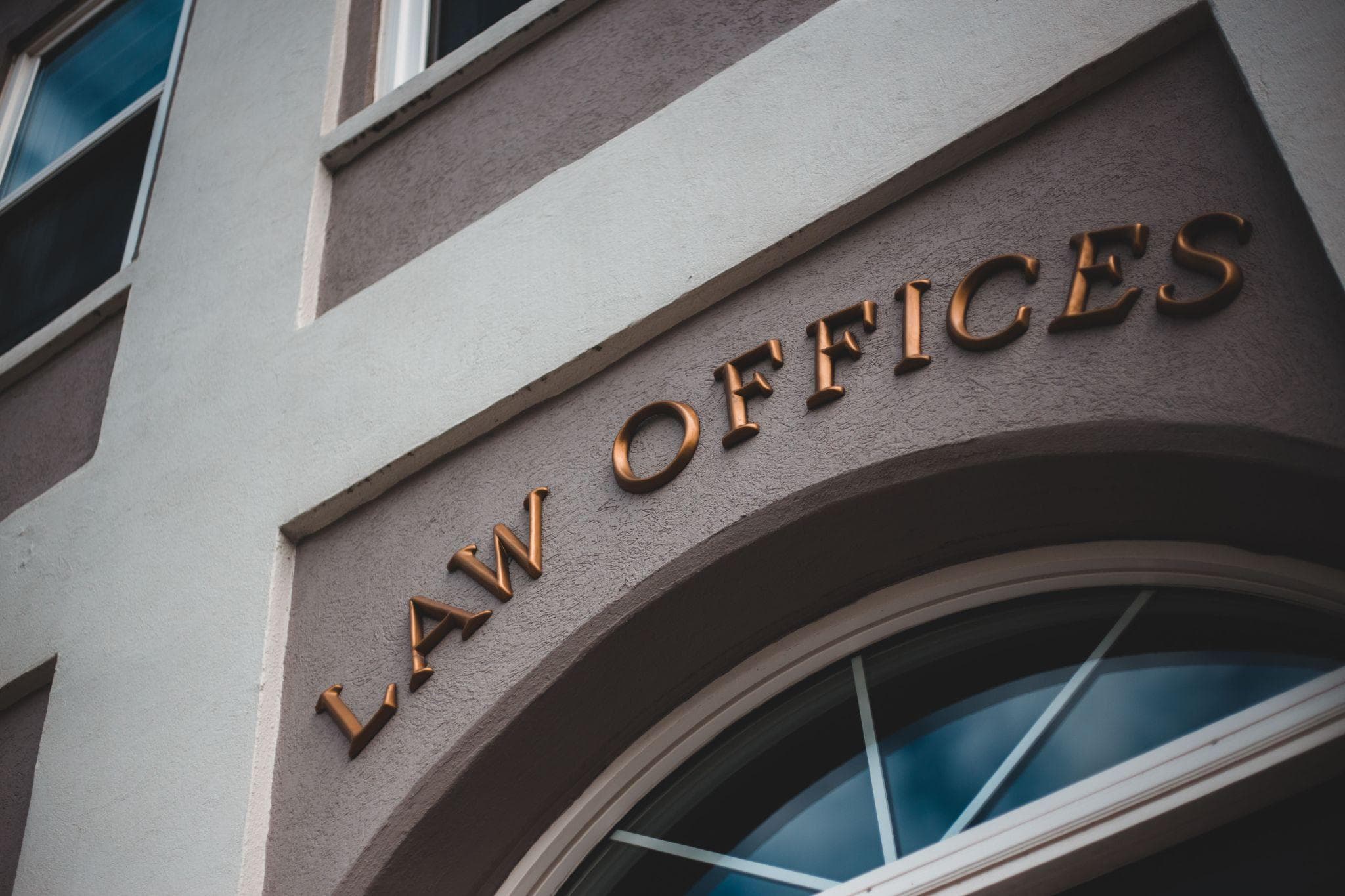 Bronze “Law Offices” lettering on the curved facade of a law firm building